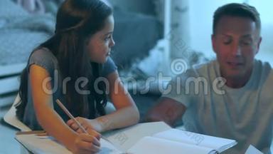 关爱的父亲帮助他的女儿做家庭作业